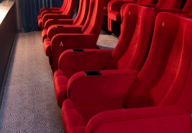 Red Cinema chairs in two rows beside a blue curtain in the Regal Cinema, Youghal, Co. Cork