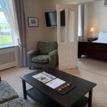 Deluxe Suite at The Walter Raleigh Hotel with a living room and large double bed.