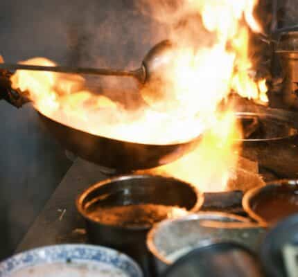 Chef cooking with hot pan on fire