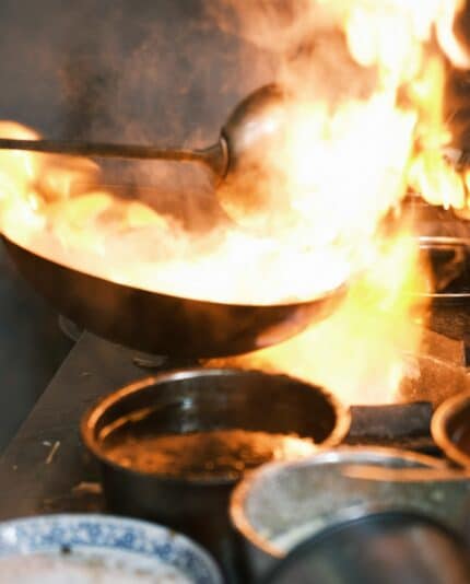 Chef cooking with hot pan on fire