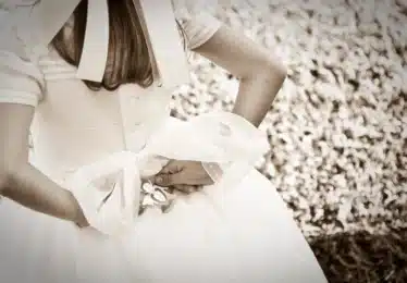 Holy communion child holds angel behind her back