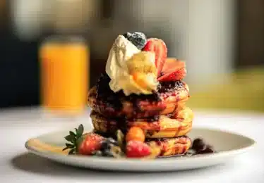 Stack of pancakes with cream and berries