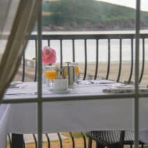 breakfast setting through a window over looking Youghal Bay