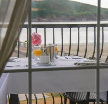 breakfast setting through a window over looking Youghal Bay