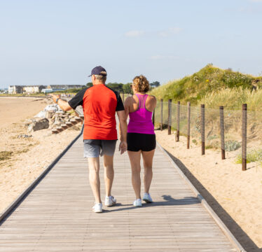 couple-on-boardwalk-youghal-cork-kachmarsky-pure-cork-source-aileen-murray-living-youghal-july25