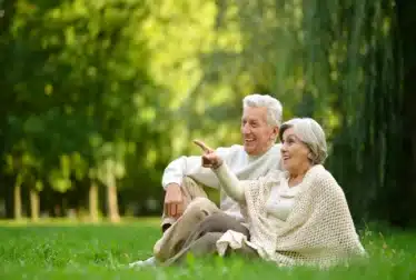 Older couple on the grass enjoying a break away