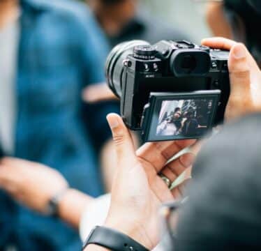 Person taking picture of two people on a camera
