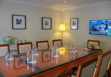 Meeting room with tv on and water bottles on tables