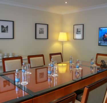 Meeting room with tv on and water bottles on tables