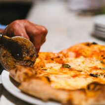 Chef cutting pizza with pizza cuttter